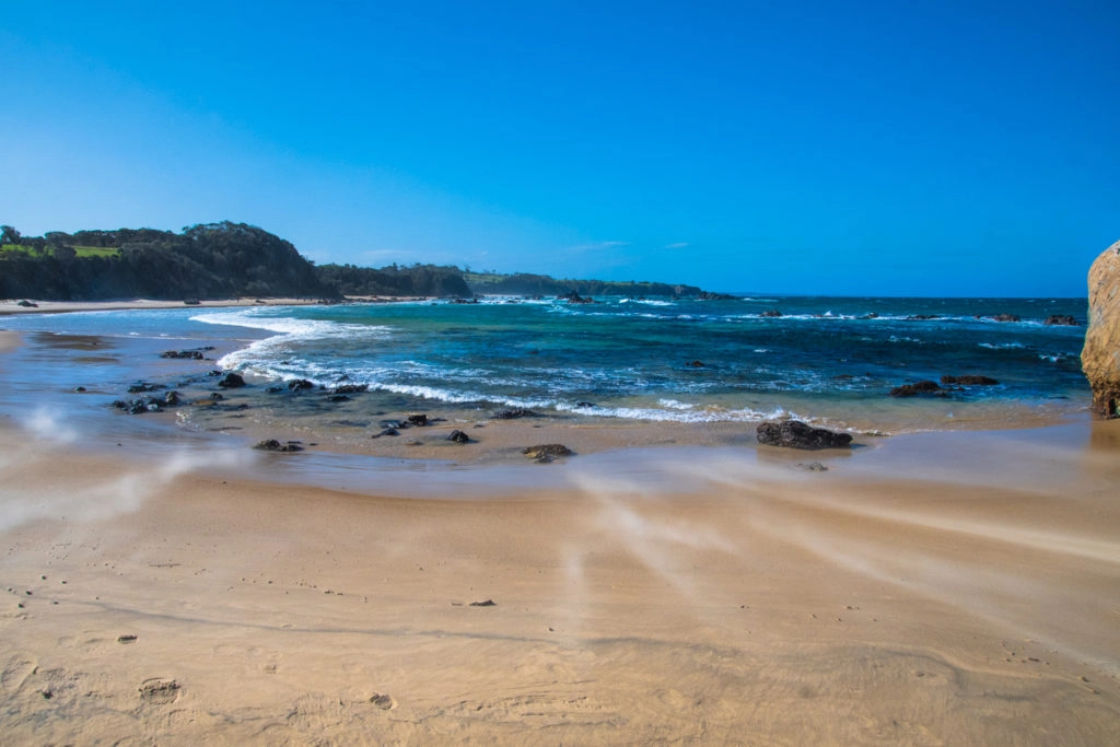 Strong wind blowing sand along Narooma surf beach